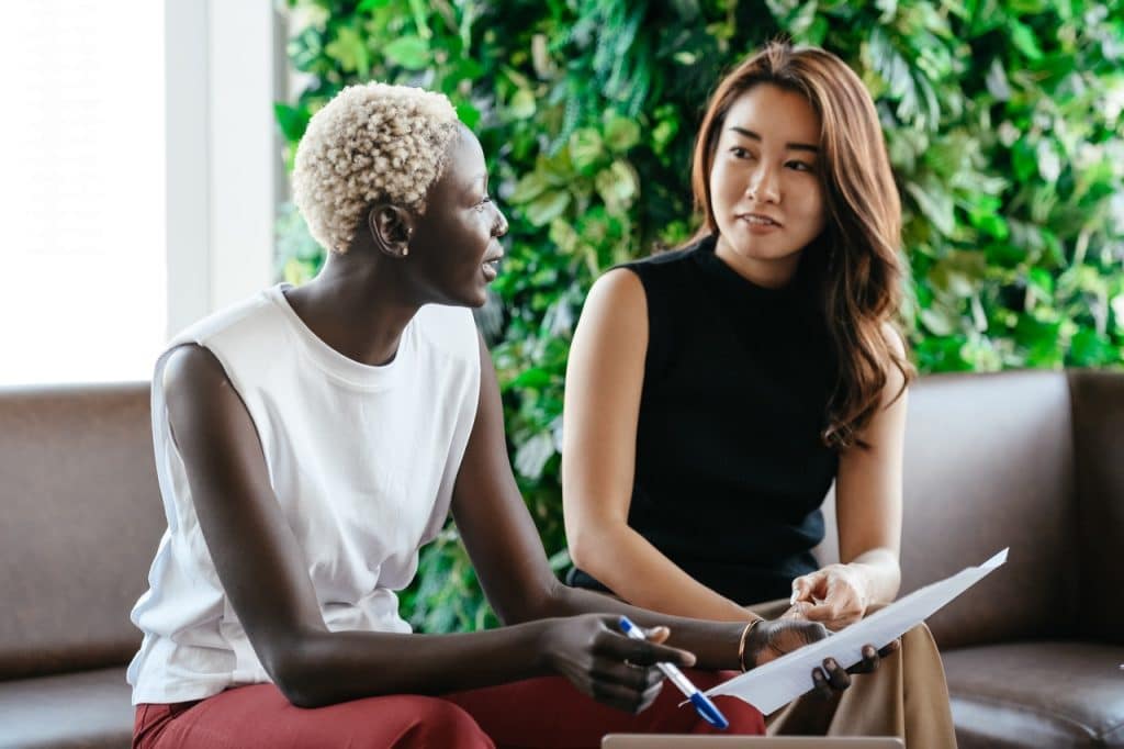 An Asian women listening to a black female employee